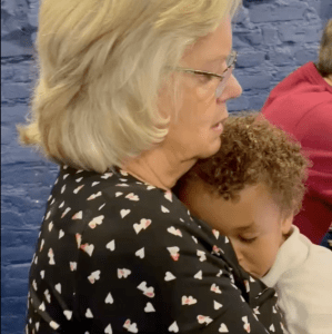 young child sleeping on his grandmother's chest